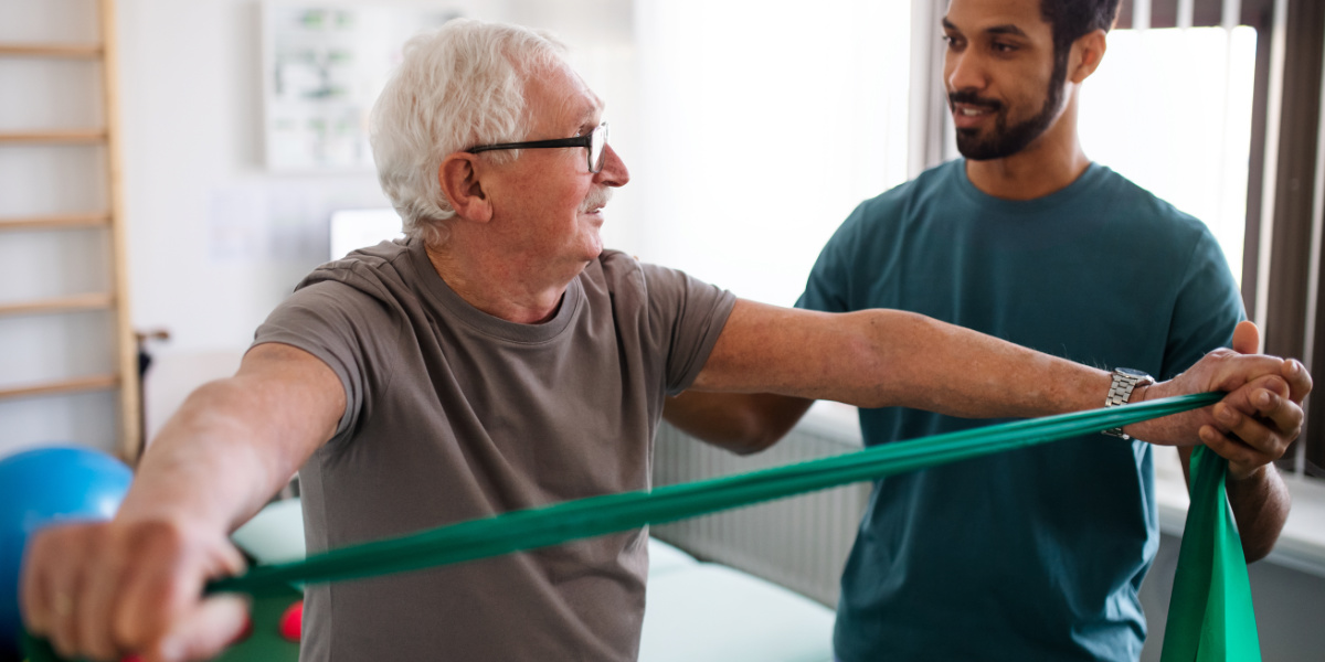 A physical therapist works with a patient on a resistance band